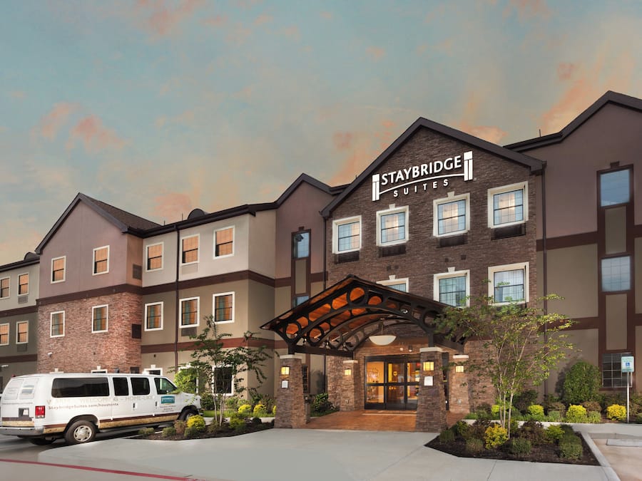 A Staybridge Suites hotel with a brick facade, multiple windows, and a covered entrance.