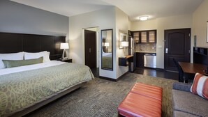 A hotel room with a large bed, a desk, a kitchenette, and a seating area. - Staybridge Suites Houston I-10 West-beltway 8 by IHG (Houston)