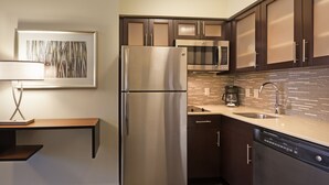 A modern kitchen with a stainless steel refrigerator, a microwave, and a dishwasher. - Staybridge Suites Houston I-10 West-beltway 8 by IHG (Houston)
