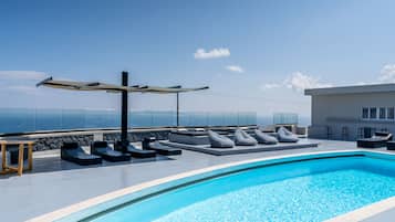 Un área de piscina moderna al aire libre con sillas de descanso y una pérgola.