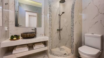 Une salle de bain moderne avec une douche à la forme arrondie, un lavabo en marbre et des toilettes.