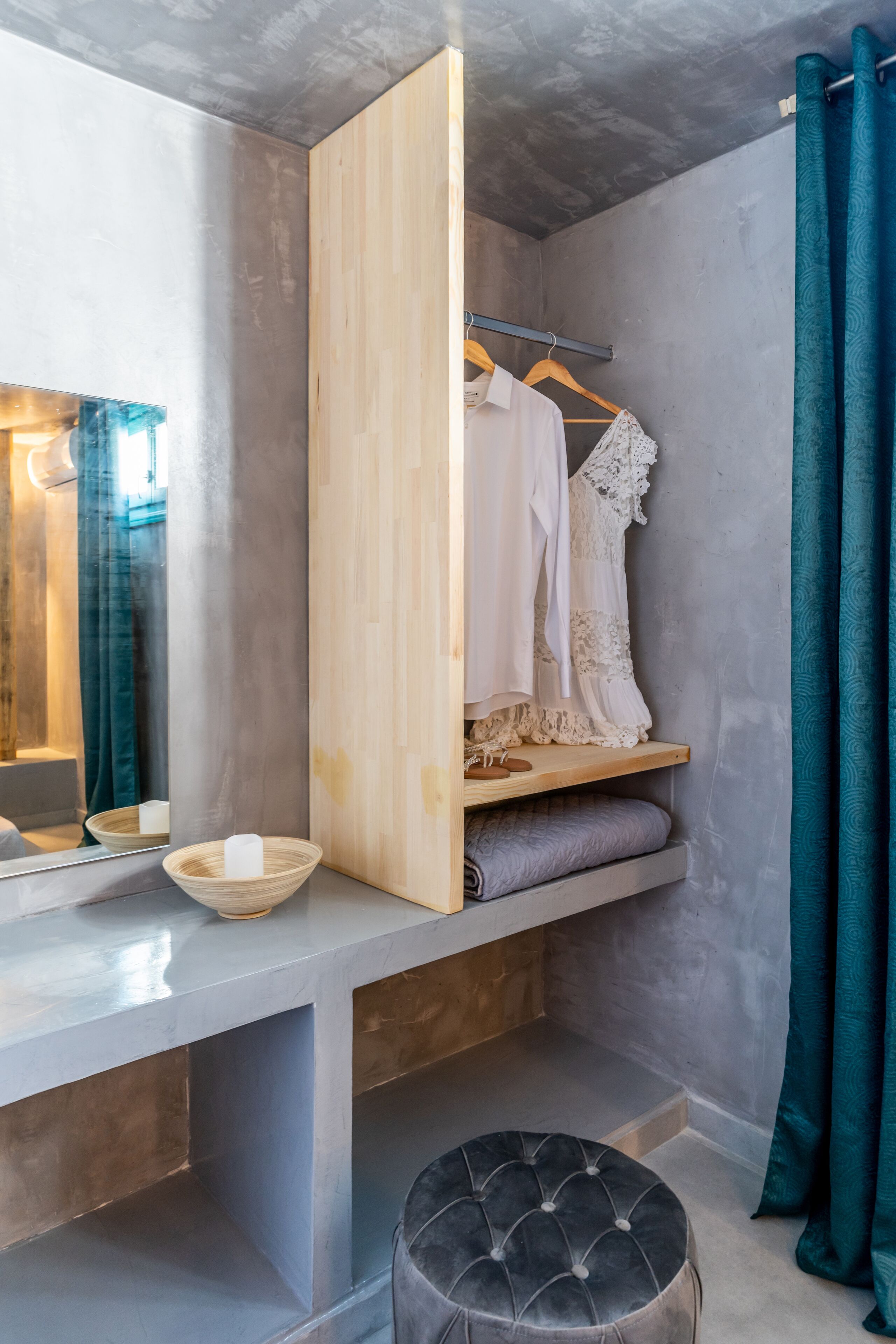Un baño moderno con tocador de madera, un espejo, un perchero y un reposapiés negro.
