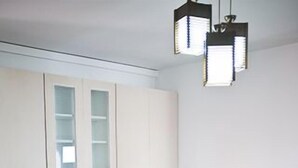 Una cocina compacta con armarios blancos, encimera de madera y una mesa de comedor con cuatro sillas.