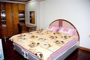 A bedroom with a bed, a wooden wardrobe, a desk, and a chair. - Lotus Condo Downtown (Pak Kret)