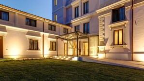 A multi-story hotel with a covered entrance, a well-maintained lawn, and a classic architectural style. - Hotel Parco delle Fontane (Syracuse)