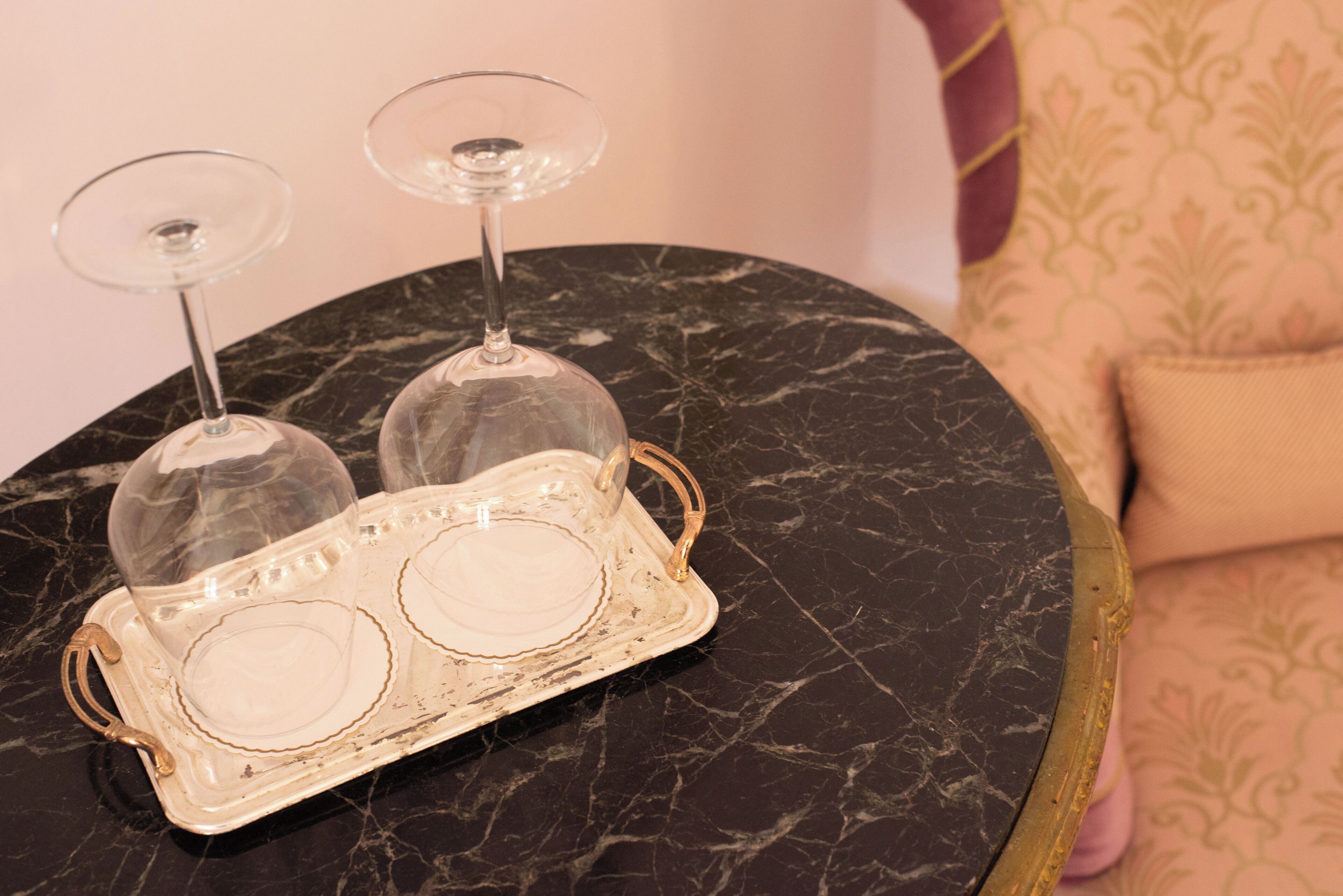 Une table en marbre sur laquelle se trouve un plateau avec deux verres à vin.