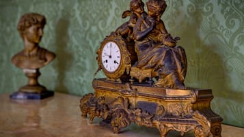 Un reloj detallado con intrincadas tallas y una escultura de busto sobre una mesa.