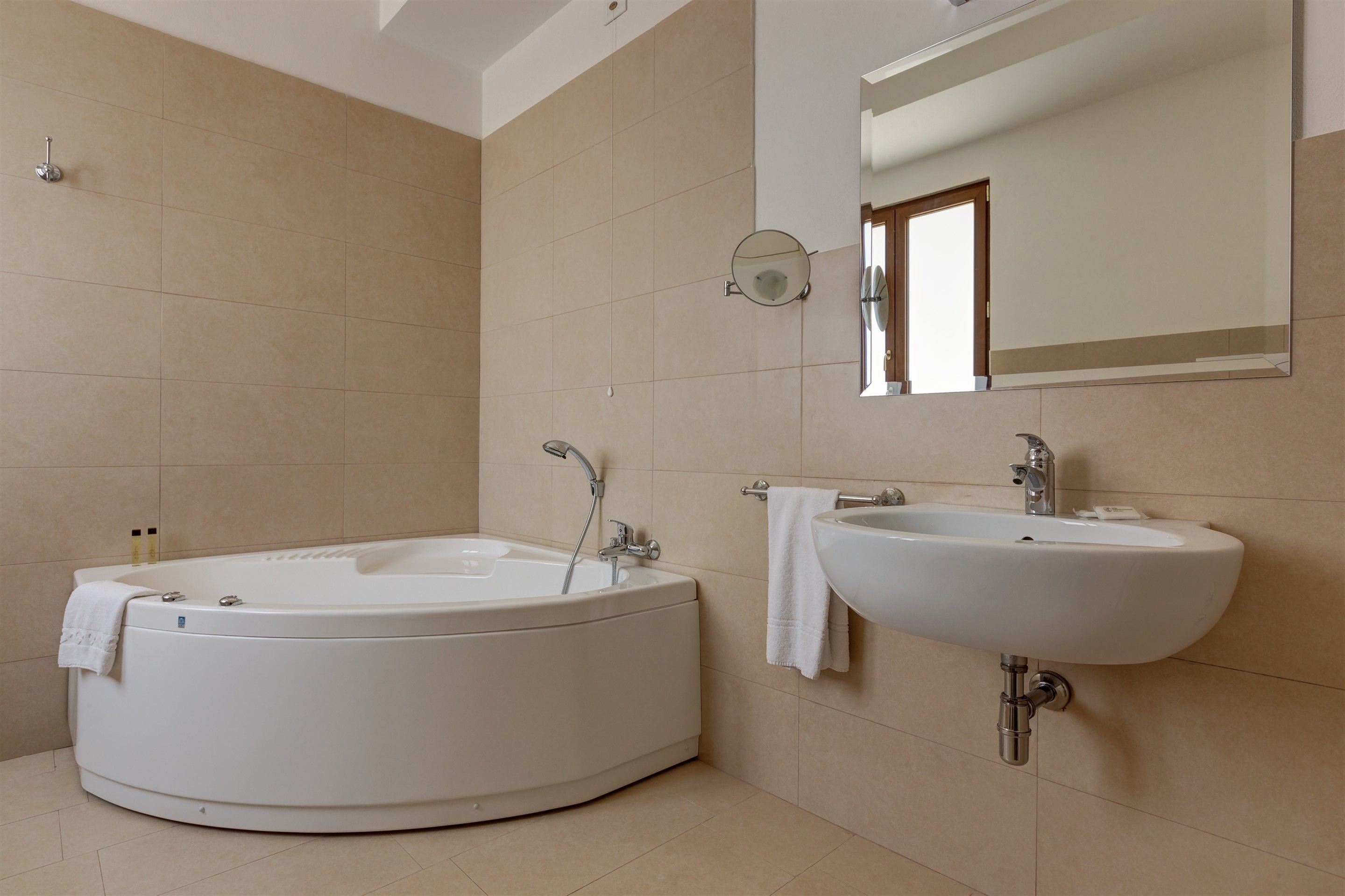 Ein modernes Badezimmer mit freistehender Badewanne, einem wandmontierten Waschbecken und einem Spiegel darüber.