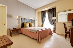 Una habitación de hotel con cama, mesita de noche, lámpara, silla y un espejo en la pared.