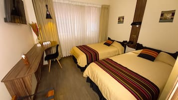 Two single beds with matching headboards, a desk, and a TV for a comfortable stay.