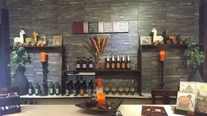 A bar area with shelves of bottles, a candle, and decorative items. - Hotel Sagarnaga (La Paz)