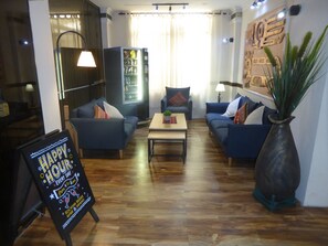 Un salon moderne avec deux canapés, une table basse et un grand vase.