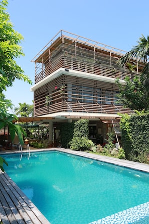 A multi-story building with a pool in front.