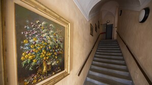 A staircase with a framed painting of flowers on the wall. - Albergo dell'Academia (Mondovi)