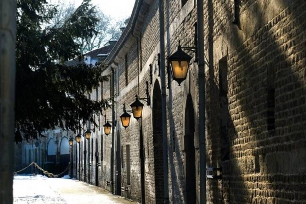 Una calle estrecha flanqueada por edificios de ladrillo y farolas tradicionales.