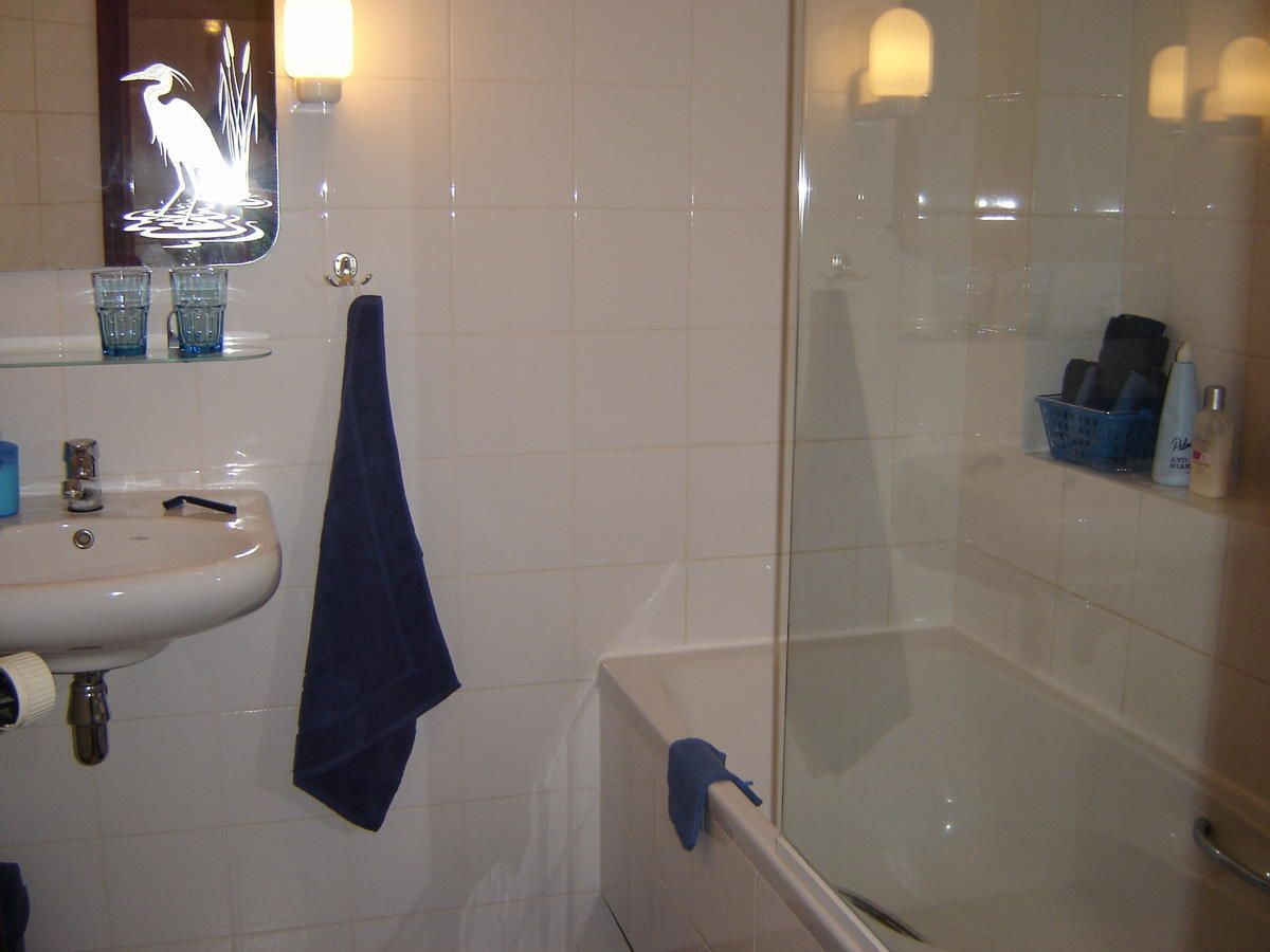 A bathroom with a sink, mirror, and bathtub.