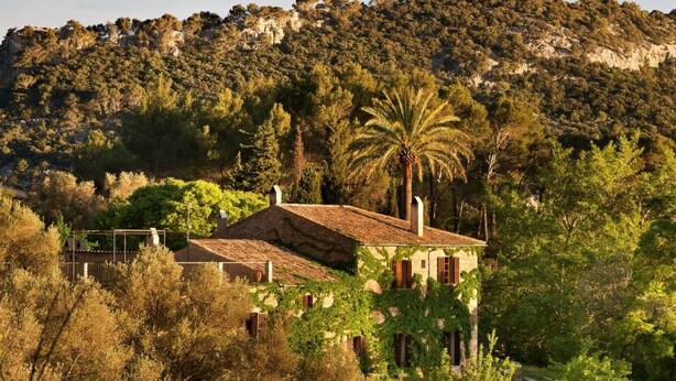 A rustic villa with a tiled roof, surrounded by lush greenery and a mountainous backdrop. - Hotel Mirabó De Valldemossa (Valldemossa)