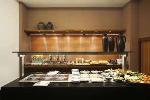 A buffet setup with various food items and utensils.
