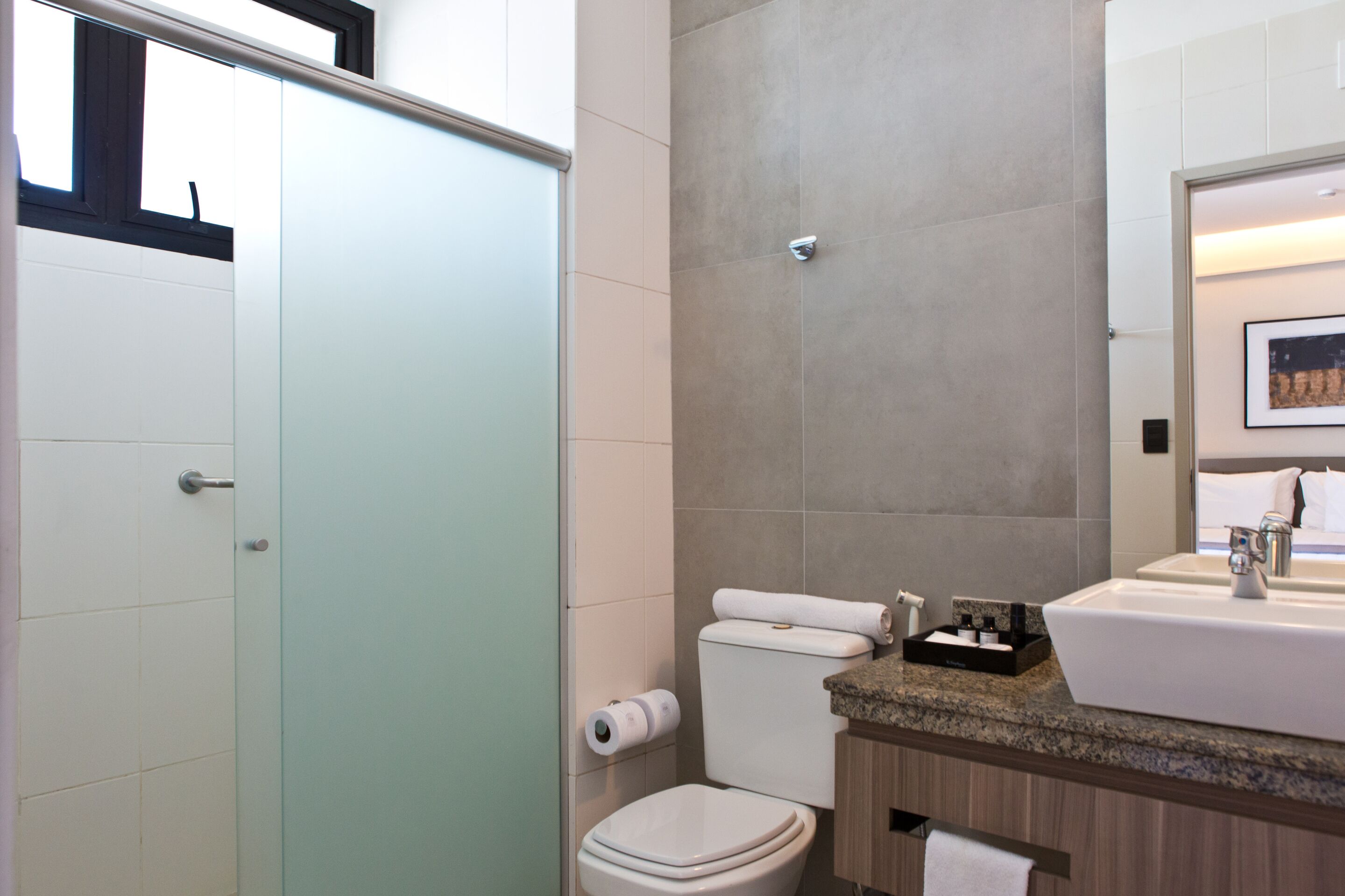 A modern bathroom with a toilet, sink, and shower.