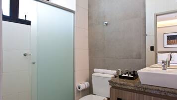 A modern bathroom with a toilet, sink, and shower.