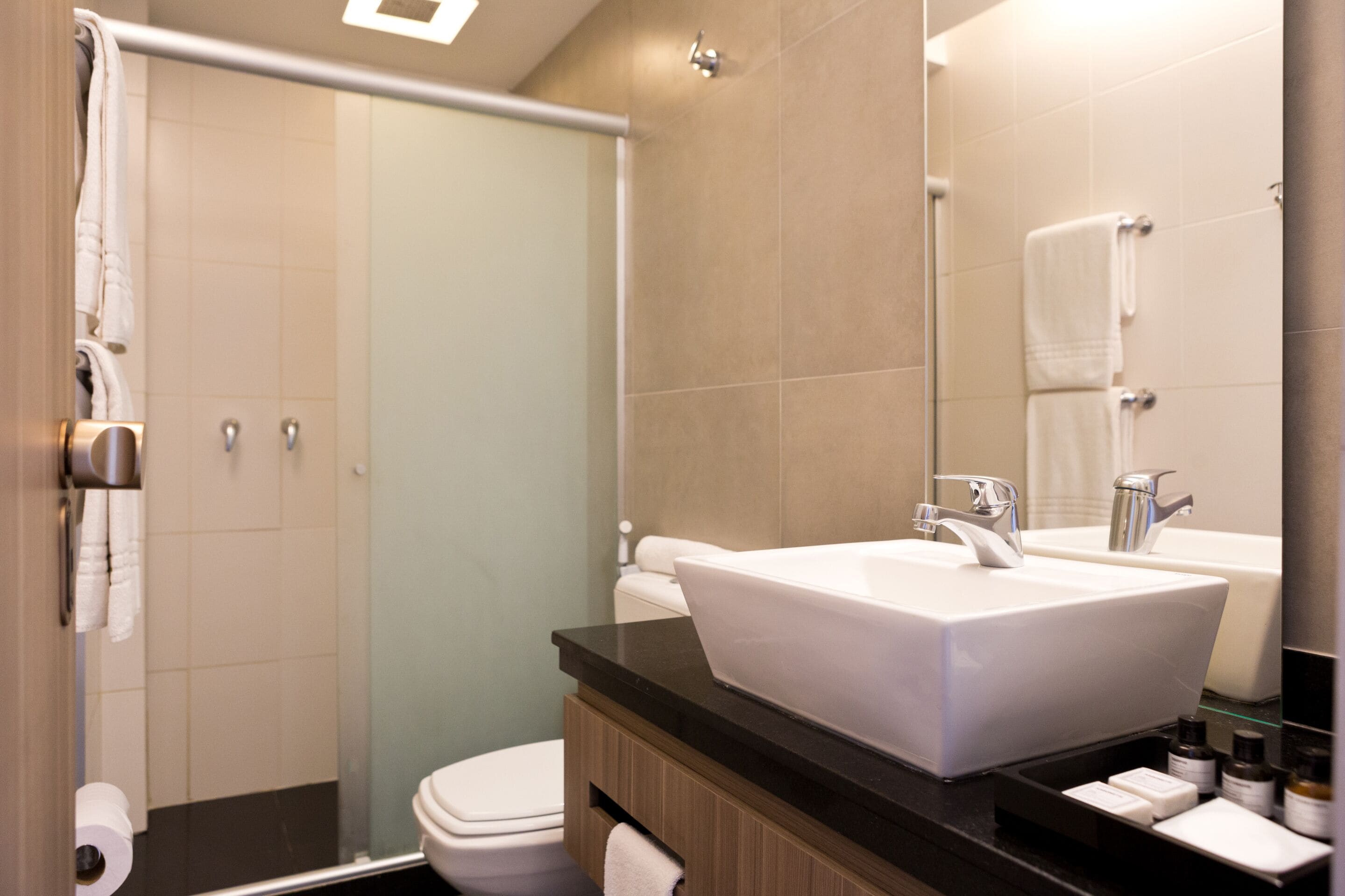 A modern bathroom with a large sink, a toilet, and a shower.