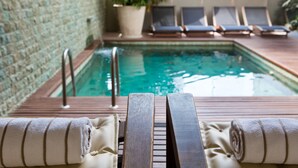 A poolside area with lounge chairs and a wooden deck. - Ritz Hotel Leblon (Rio de Janeiro)