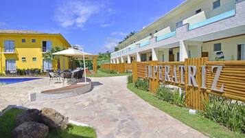 Experience the RATRIZ hotel's serene outdoor space, featuring a pool area with lounge chairs and a table.