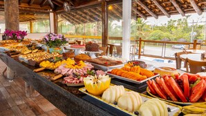Un buffet proposant une variété de plats et offrant une vue sur un paysage tropical.