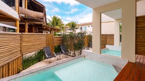 Un espace piscine avec des chaises longues, une terrasse en bois et une vue sur les bâtiments environnants.