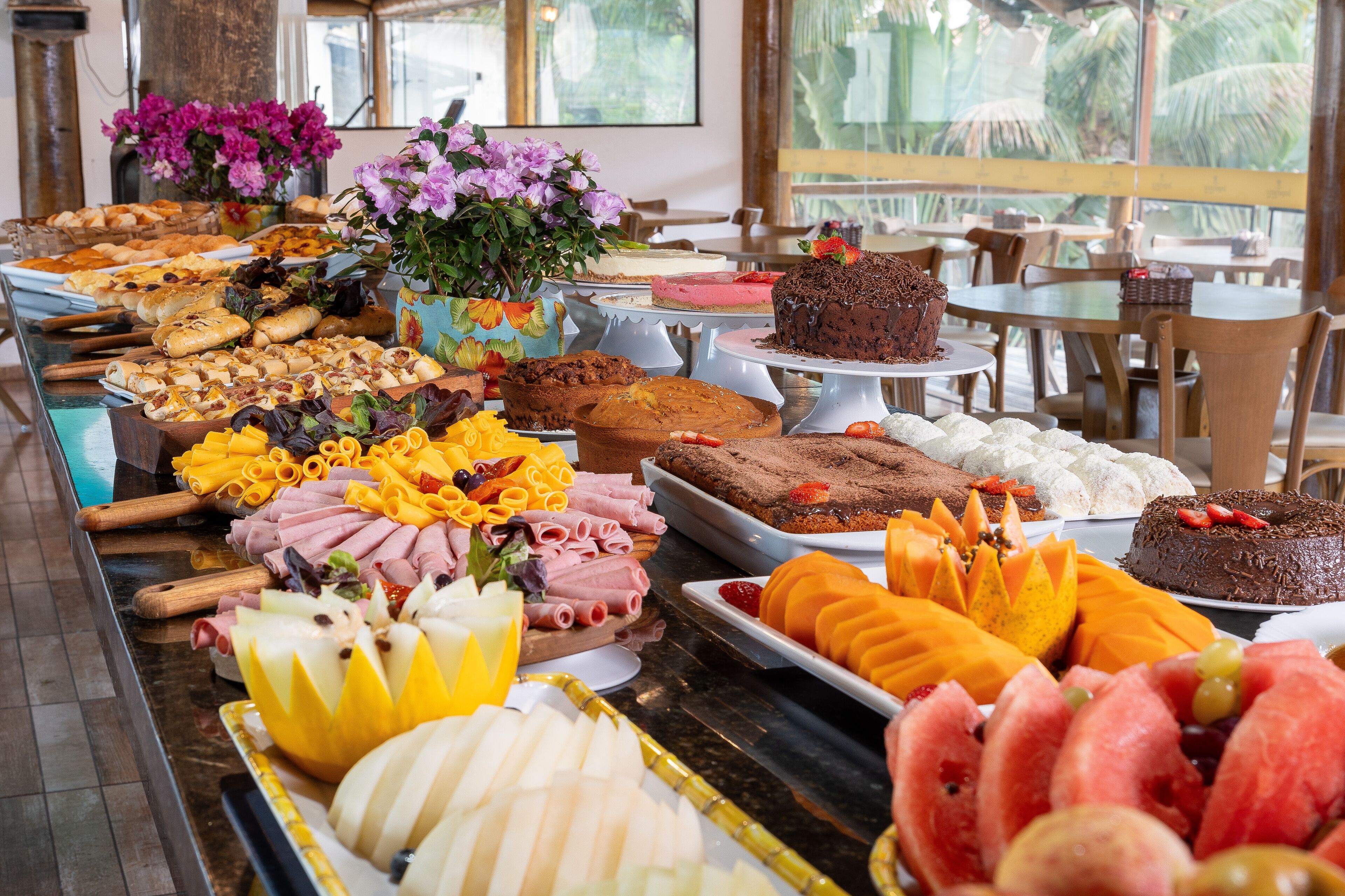 A buffet with various food items including pastries, cakes, and fruits.