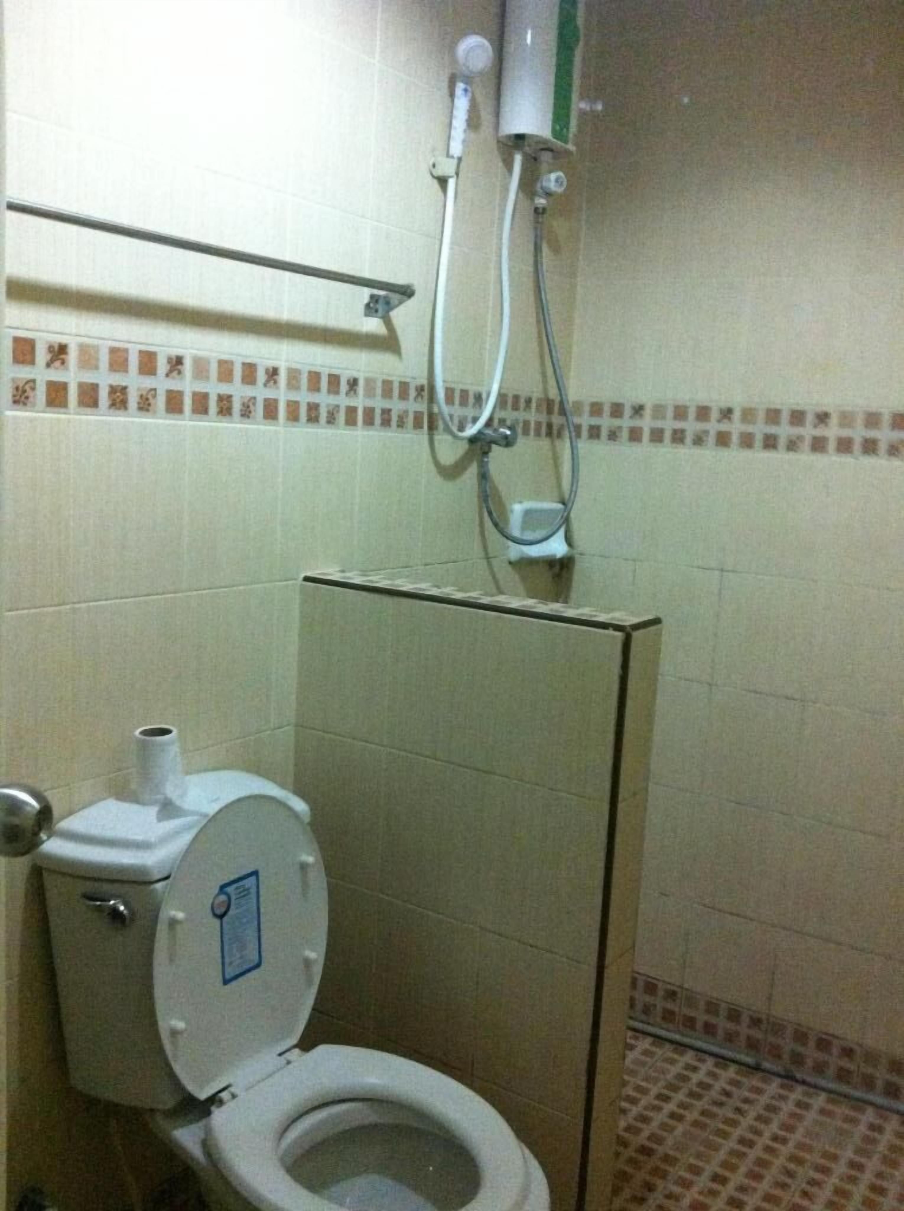 Ein kleines Badezimmer mit Toilette, Dusche und Handtuchhalter.