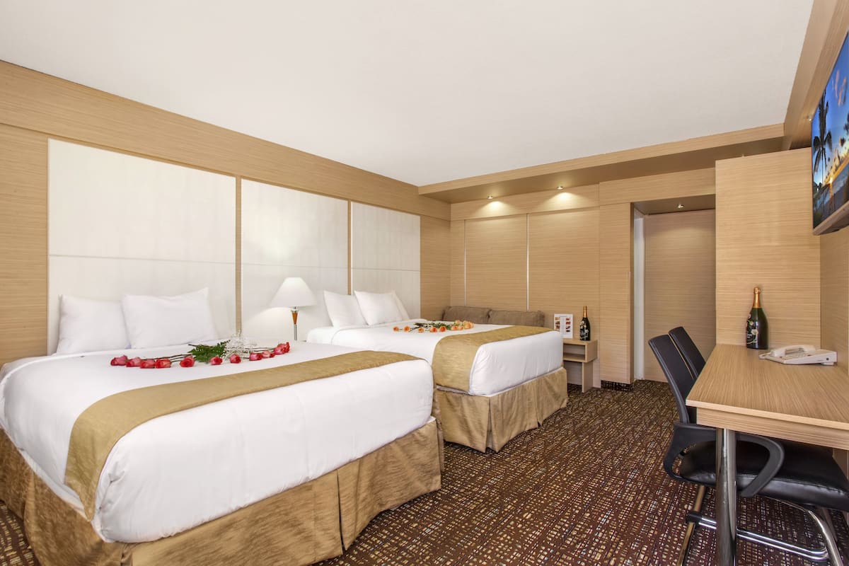 Ein Hotelzimmer mit zwei Betten, einem Schreibtisch und einem Stuhl.