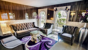 Ein moderner Lounge-Bereich mit einer Couch, Sesseln und einem Couchtisch.
