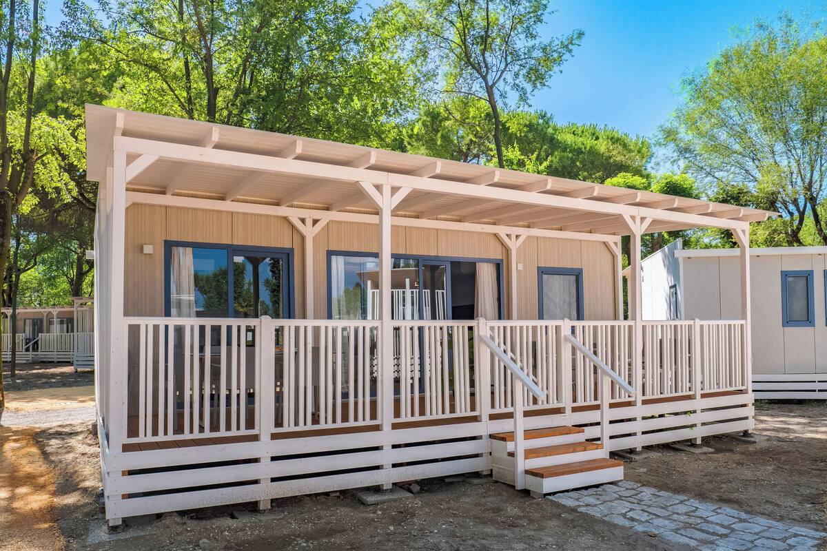 Eine eingeschossige Holzhütte mit einer Veranda und einer Treppe zum Eingang.