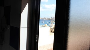 Vista de uma varanda com vista para uma marina, com barcos e edifícios.