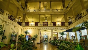 A spacious lobby with a high ceiling, multiple balconies, and a variety of plants. - Gran Hotel de Merida (Mérida)