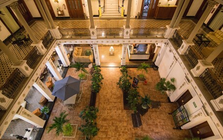 A spacious atrium with a central staircase, multiple balconies, and a variety of seating areas.