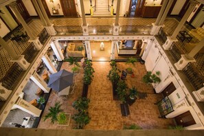 A spacious atrium with a central staircase, multiple balconies, and a variety of seating areas. - Gran Hotel de Merida (Mérida)
