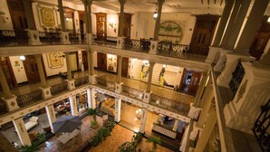 A multi-level atrium with a central open space, balconies, and a variety of seating areas. - Gran Hotel de Merida (Mérida)