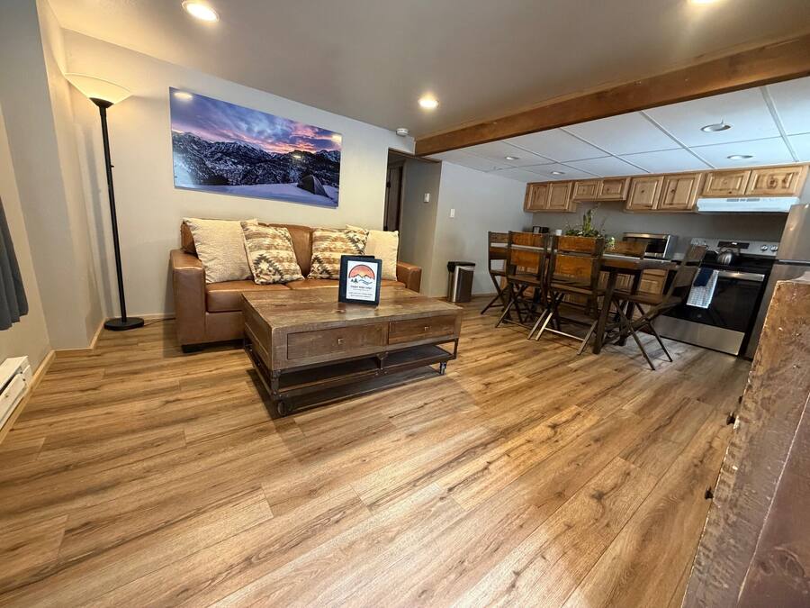 Uma sala de estar moderna com sofá, mesa de centro e área de jantar com cadeiras e mesa.