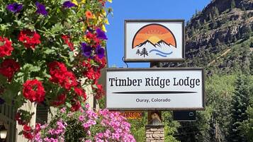 Señal de Timber Ridge Lodge en Ouray, Colorado, con un logotipo que presenta una montaña y un sol.