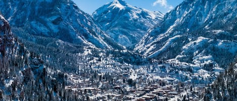 A snow-covered mountain town with dense forests and a central valley.