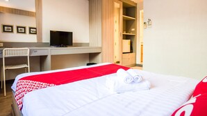 A hotel room with a bed, a desk, a chair, and a television. - OYO 437 Hostel Na Nara (Bangkok)