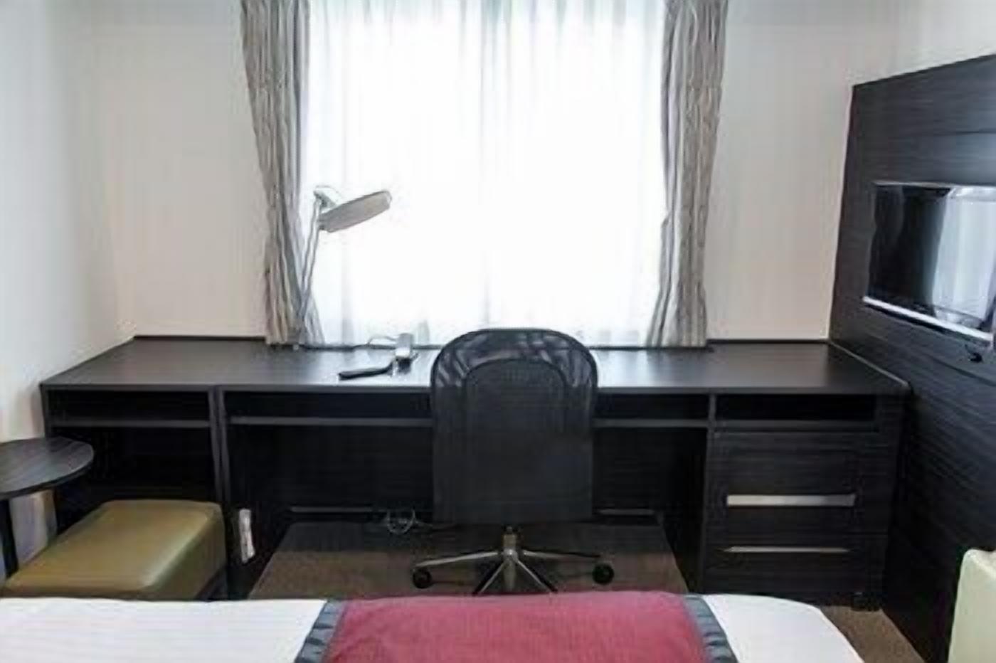 خزنة داخل الغرفة ومكتب وملاءات أسرّة