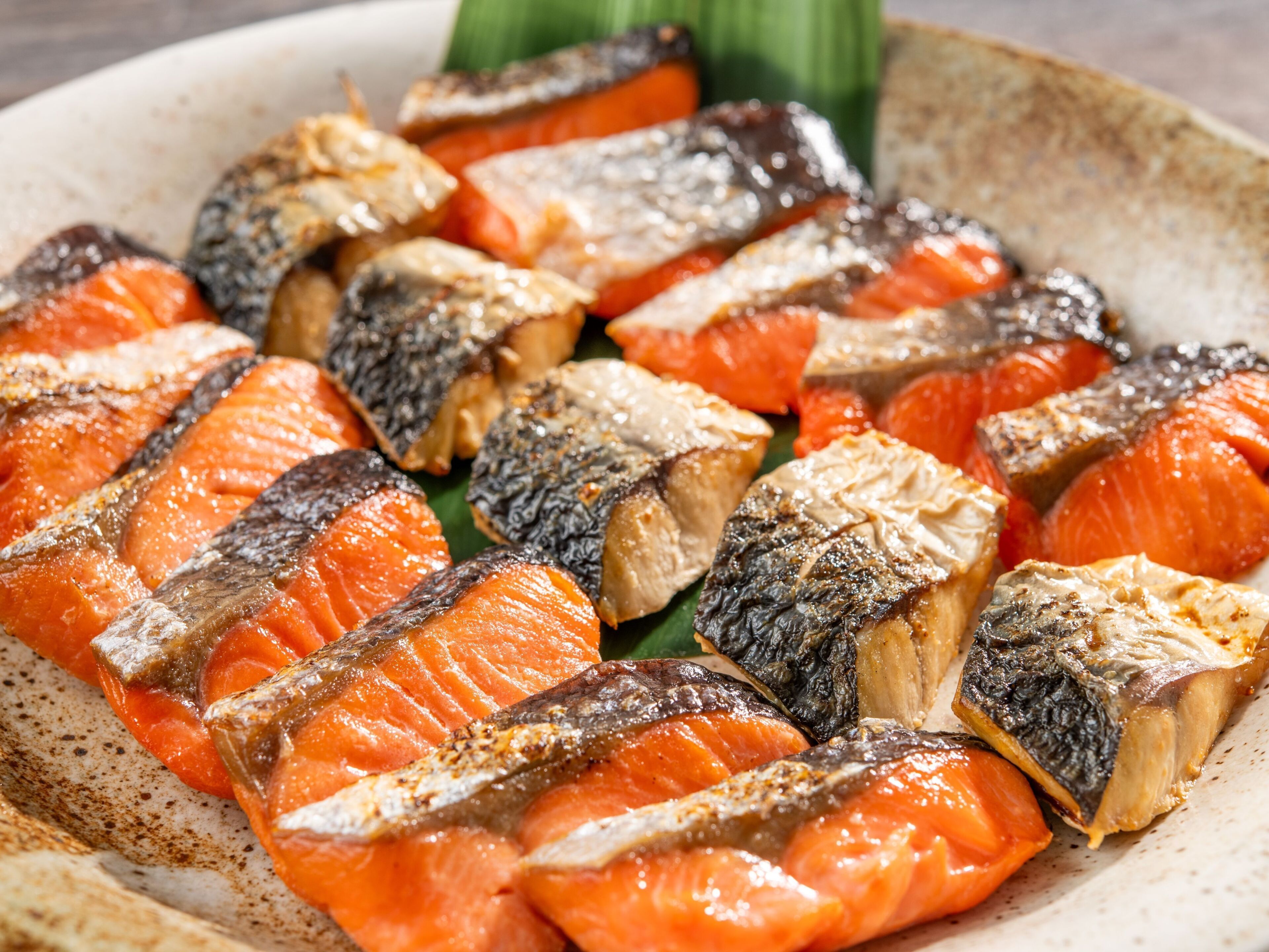 Un plato de pescado a la parrilla y verduras.