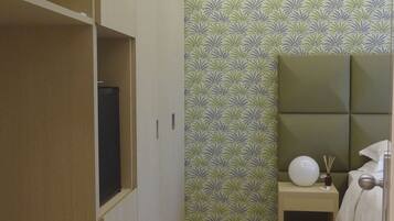 Un dormitorio con cama, mesita de noche y armario.