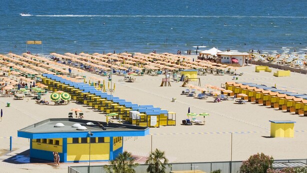 A beach with numerous sunbeds and umbrellas, a lifeguard tower, and a clear view of the sea. - Hotel Metropol (Chioggia)