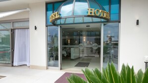 A hotel entrance with a glass facade, a large sign above the doors, and a visible interior with tables and chairs. - Hotel Metropol (Chioggia)
