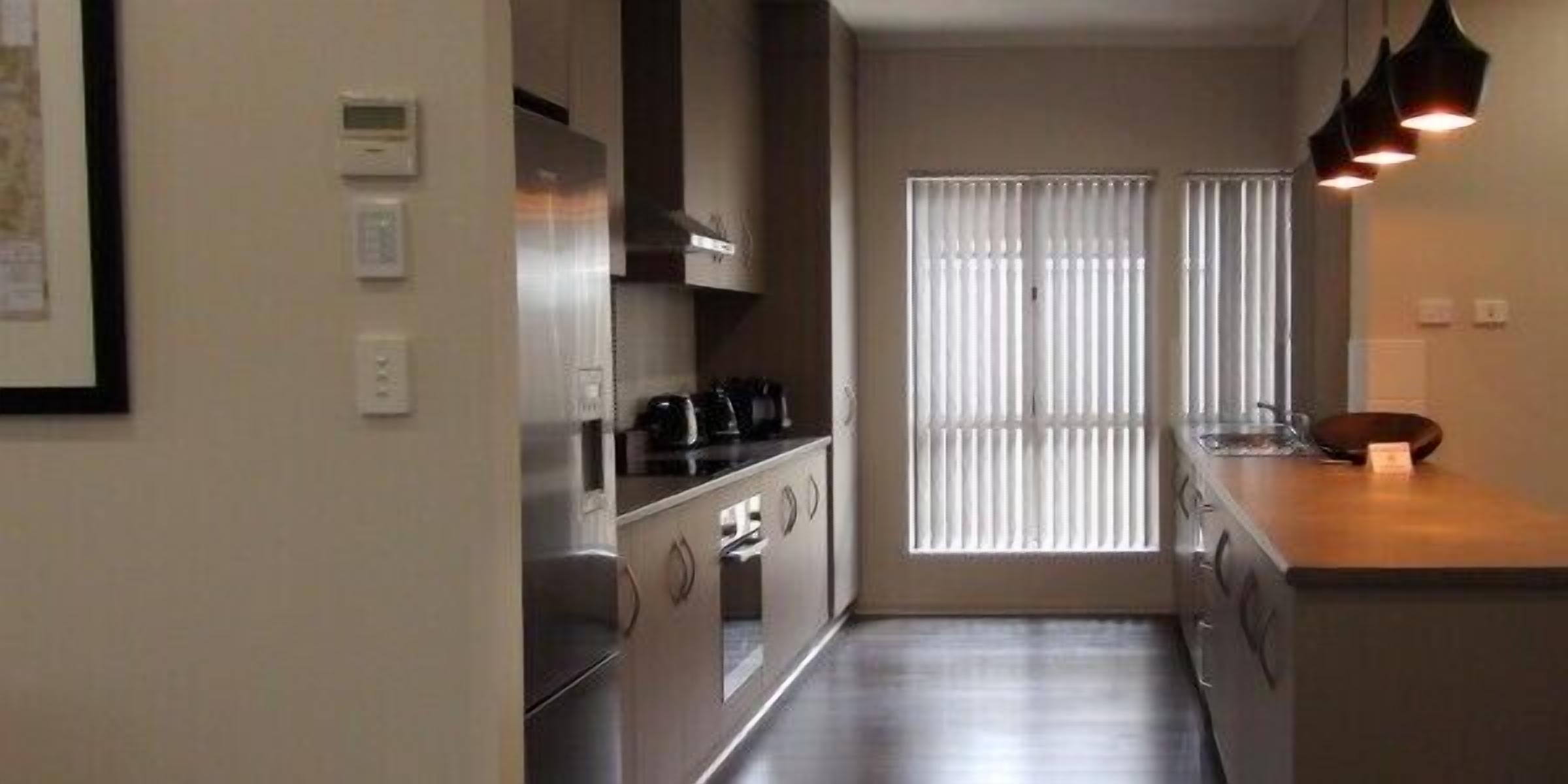 A compact kitchen with a stove, oven, and a coffee maker on the counter.