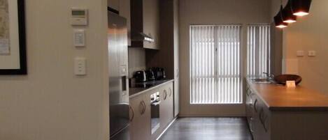 A compact kitchen with a stove, oven, and a coffee maker on the counter.